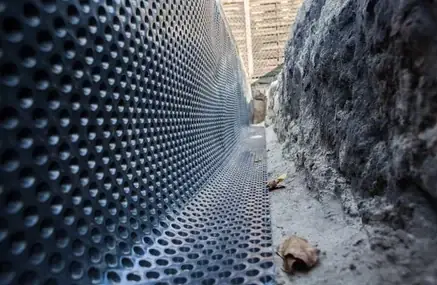 Dimpled membrane installed at base of footing